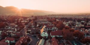 An overlook of a town with the sun setting behind a mountain