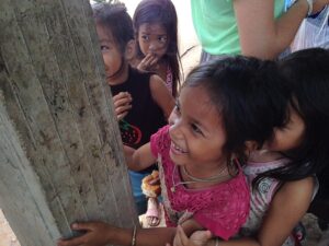 children looking at a wooden post and laughing