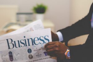 a man opening a newspaper with the word "Business" written on it