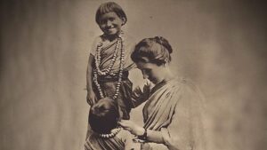 An old black and white photograph of a lady and two small children