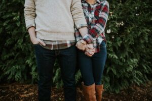 A  man and woman standing next to eachother holding hands