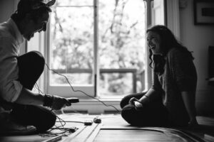 a man and woman sitting on the floor laughing together