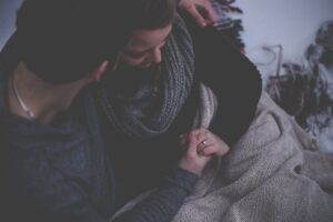 A man and woman sitting closely together holding hands