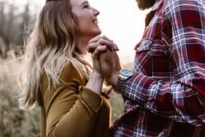 A man and woman holding hands and smiling at eachother