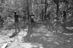 Black and white photo of several young people building a wooden fence
