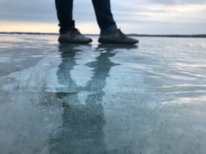 View of someone's shoes standing in very shallow water