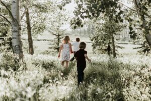 Three children running through the woods