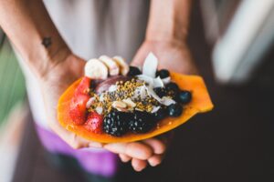 A person holding a small platter of fruit