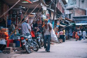 A man walking down the path of a city market.