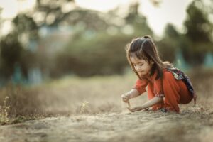 A young girl playing with sand