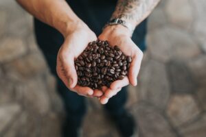 A person holding coffee beans in their hands