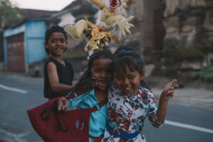 Three children laughing in the street