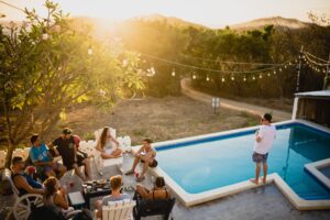 a group of people sitting in a circle next to a swimming pool