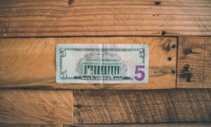 A five dollar bill on a wooden table