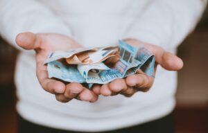 a person's open hands holding paper currency