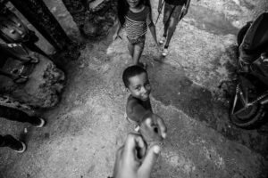 a young boy reaching his hand out to the camera