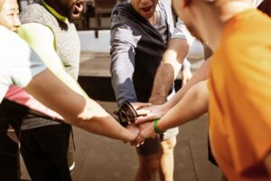 a group of people in a circle putting their hands together