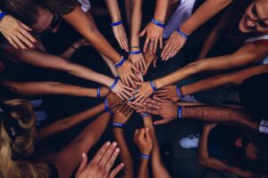 Several people in a circle putting their hands together