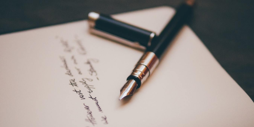 A pen resting on a handwritten note.