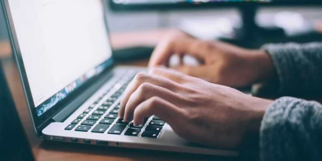 A person typing on a laptop computer