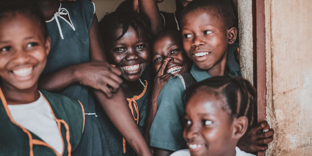 A group of kids laughing in a doorway